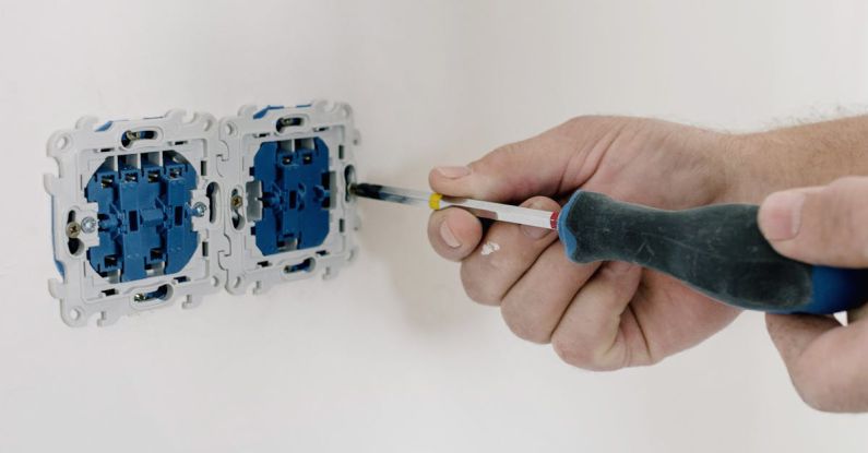 Electrical Repairs - An Electrician Using Screwdriver to Repair the AC Power Plugs and Sockets