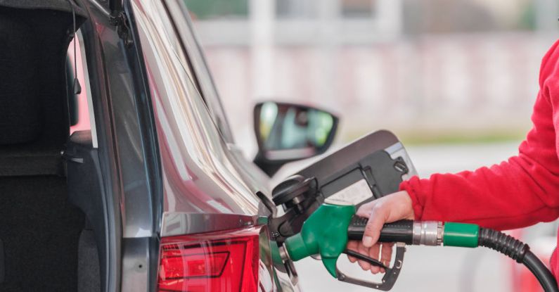 Fuel Efficiency - Pumping gas at gas pump. Closeup of man pumping gasoline fuel in car at gas station.