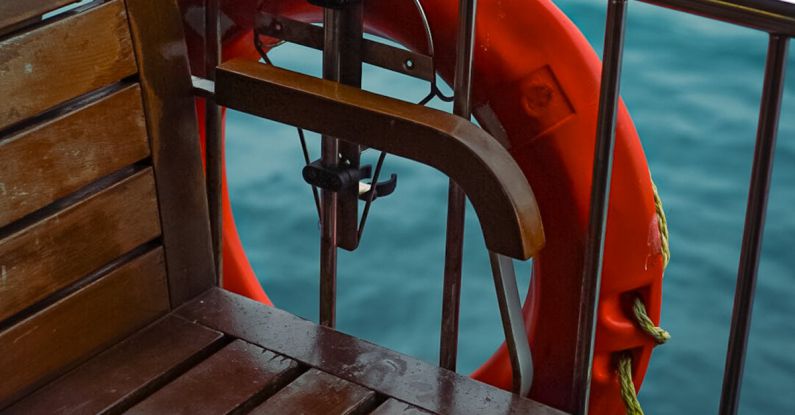 Safety Features - A wooden bench and life preserver on a boat