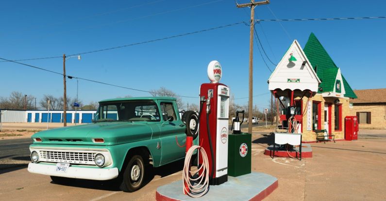 Diesel Vs. Petrol - Green Single-cab Pickup Truck Beside a Gas Pump Station