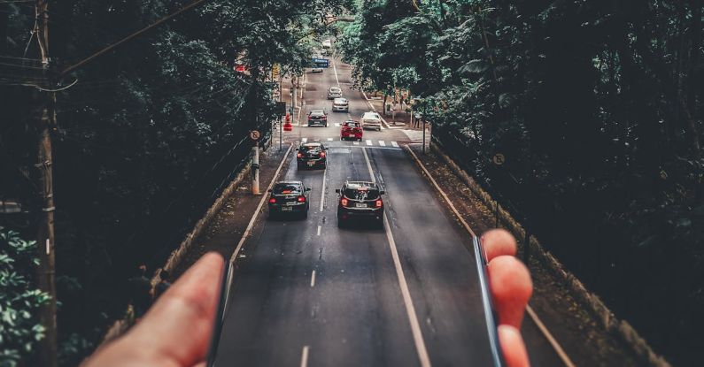 Car Sharing - Forced Perspective Photography of Cars Running on Road Below Smartphone